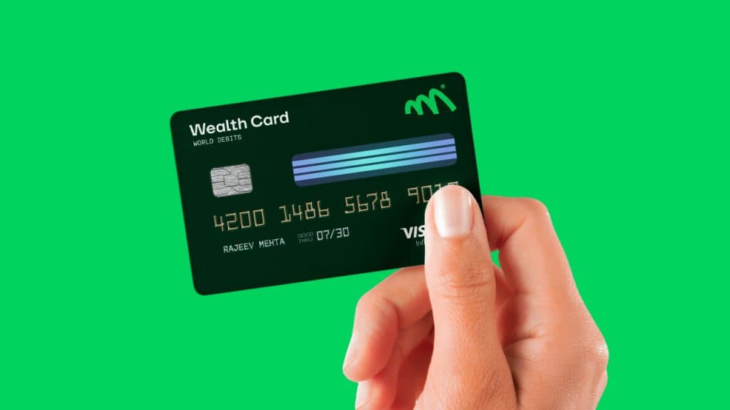 Monmove wealth card mockup held in hand on a green background